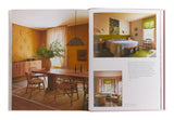 Open book showing interior design images of a room with a dining table and chairs.